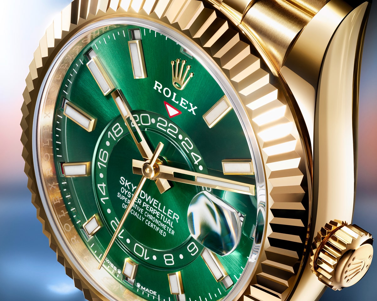 Luxury Sky-Dweller yellow gold watch with green dial, fluted bezel, annual calendar, and dual time zone display shown in detailed close-up view