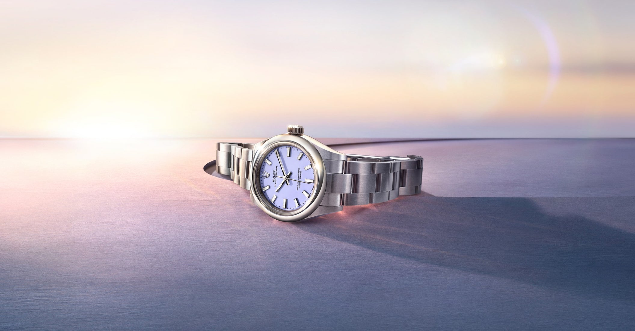 Rolex Oyster Perpetual 2025 model M276200-0008 shown in an ambient environment, featuring the watch’s sleek silver case, smooth bezel, and elegant dial with baton hour markers, set against a softly lit background emphasizing its refined craftsmanship.