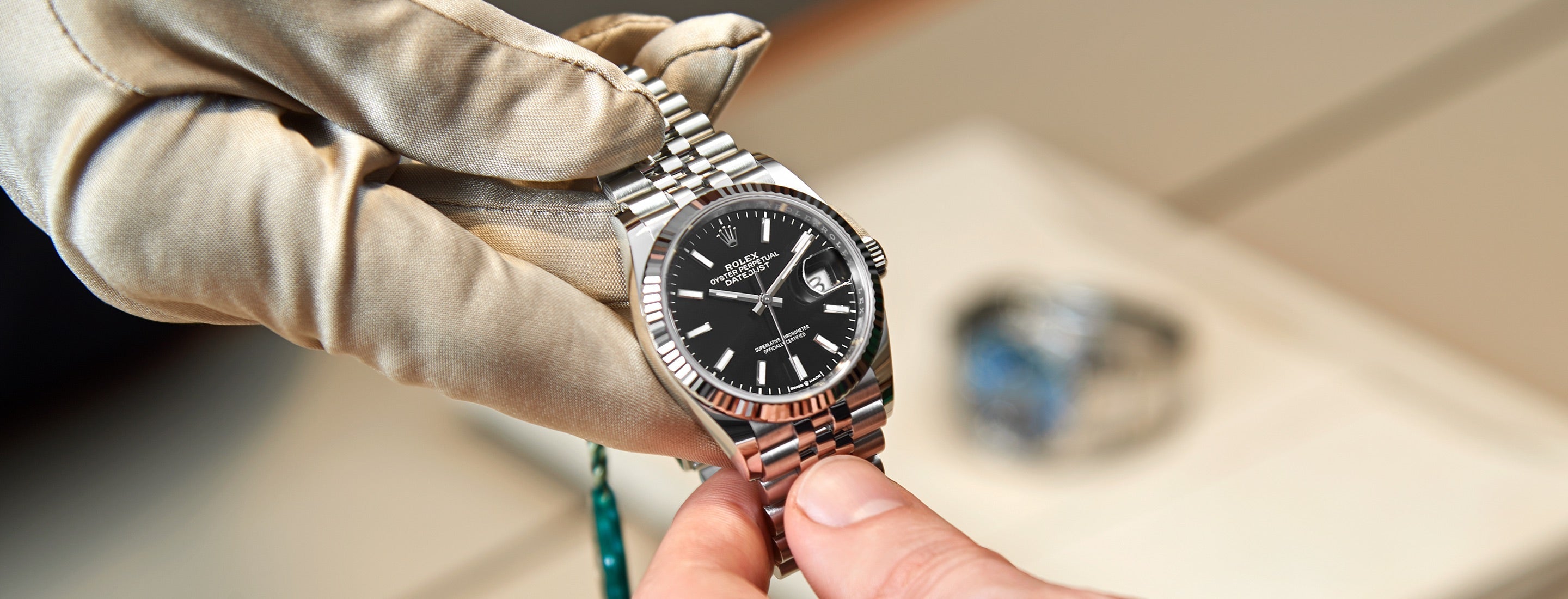 The image displays the Rolex servicing procedure, focusing on the precise manipulation of watch components with specialized tools. It highlights the meticulous care and expertise involved in maintaining Rolex timepieces.